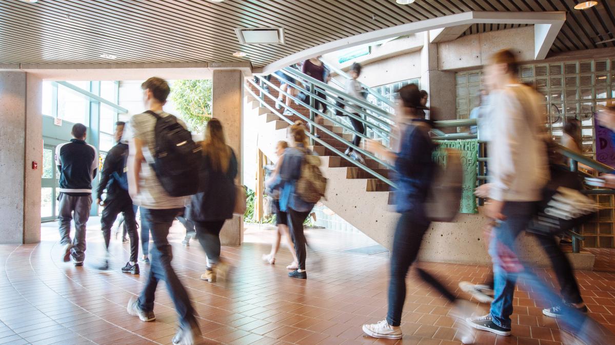 Blurred students walking to class through front foyer of school
