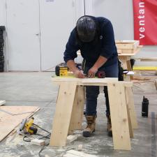 Male student marking measurements for in carpentry competition